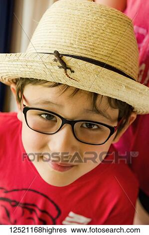 Stock Photograph - Boy with baby lizard on his tropical straw hat; Varadero, Cuba. Fotosearch