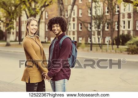 Boyfriend and girlfriend standing and holding hands on the university campus at sunset and posing for a picture; Edmonton, Alberta, Canada View Large Photo Image Stock Photograph - Boyfriend and girlfriend standing and holding hands on the university campus at sunset and posing for a picture; Edmonton, Alberta, Canada. Fotosearch