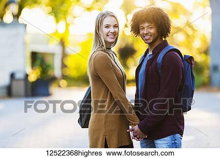 Boyfriend and girlfriend standing and holding hands on the university campus at sunset and posing for a picture; Edmonton, Alberta, Canada View Large Photo Image Stock Photograph - Boyfriend and girlfriend standing and holding hands on the university campus at sunset and posing for a picture; Edmonton, Alberta, Canada. Fotosearch