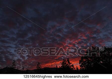 Stock Photograph - Brilliant orange clouds at sunrise, Cascade Siskiyou National Monument; Ashland, Oregon, United States of America. Fotosearch