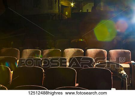 Stock Photograph - Broken chairs in an old abandoned theatre with sunlight shining in from the side; Connecticut, United States of America. Fotosearch