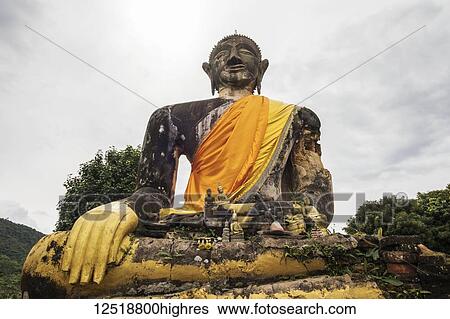 Stock Photograph - Buddha statue in the ruins of Wat Piawat temple, destroyed in the Indochina War; Muang Khoun, Xiangkhouang, Laos. Fotosearch