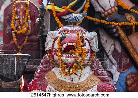 Stock Photograph - Buddhist sculptures and flowers in a temple in Durbar Square; Kathmandu, Nepal. Fotosearch