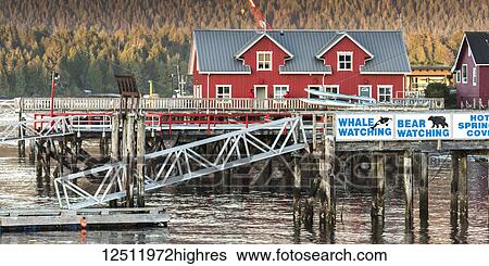 Stock Photograph - Buildings and piers along the coast with signs for whale and bear watching, Clayoquot Sound, Vancouver Island; Tofino, British Columbia, Canada. Fotosearch