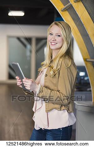 Stock Photograph - Business portrait of a beautiful young millennial professional using technology in the workplace; Sherwood Park, Alberta, Canada. Fotosearch