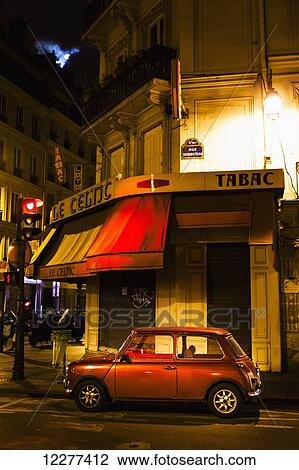 Stock Image - City street with a red hatch back car and full moon; Paris, France. Fotosearch