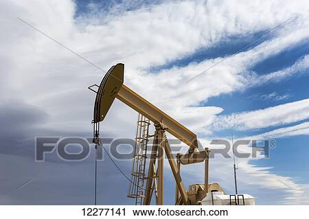 Close up and low angle of pumpjack with storm clouds and some blue sky; Alberta, Canada View Large Photo Image Stock Image - Close up and low angle of pumpjack with storm clouds and some blue sky; Alberta, Canada. Fotosearch