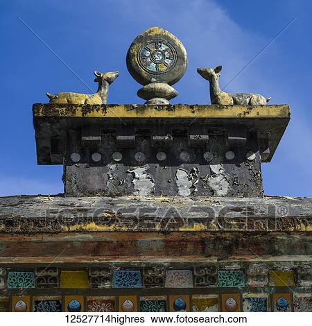 Stock Photograph - Close-up of a buddhist sculpture against a blue sky; Sikkim, India. Fotosearch