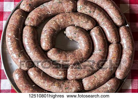 Close-up of a circle of uncooked sausage links on a round cooking tray on a red and white checkered tablecloth; Calgary, Alberta, Canada View Large Photo Image Stock Photograph - Close-up of a circle of uncooked sausage links on a round cooking tray on a red and white checkered tablecloth; Calgary, Alberta, Canada. Fotosearch