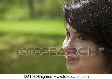 Close-up of a young woman in a park; Connecticut, United States of America View Large Photo Image Stock Photograph - Close-up of a young woman in a park; Connecticut, United States of America. Fotosearch