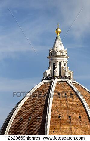 Stock Photograph - Close-up of Brunelleschi's Dome of Florence Cathedral with tourists on the viewing platform and blue sky; Florence, Tuscany, Italy. Fotosearch