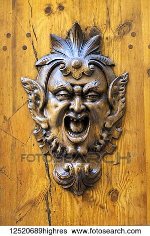 Close-up of metal face on wooden door View Large Photo Image Stock Photograph - Close-up of metal face on wooden door. Fotosearch