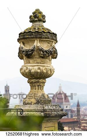 Stock Photograph - Close-up of stone urn on top of column with dome of Florence Cathedral and towers in the background; Florence, Tuscany, Italy. Fotosearch