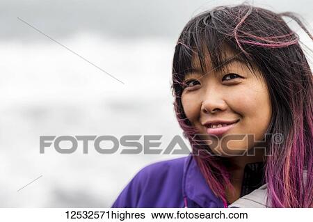 Stock Photograph - Close-up portrait of a Filipino woman with dyed pink hair; Iceland. Fotosearch
