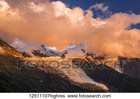 Clouds over Mont Blanc and Bossons Glacier glowing at sunset, Alps; Chamonix-Mont-Blanc, Haute-Savoie, France View Large Photo Image Stock Photograph - Clouds over Mont Blanc and Bossons Glacier glowing at sunset, Alps; Chamonix-Mont-Blanc, Haute-Savoie, France. Fotosearch