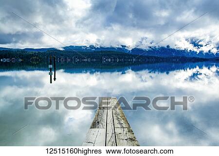 Stock Photograph - Clouds reflected in the tranquil ocean water off the coast of Tofino, Vancouver Island; Tofino, British Columbia, Canada. Fotosearch