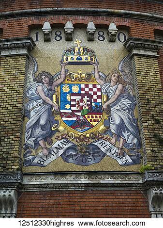 Stock Photograph - Colourful and symbolic crest painted on the side of a rounded brick wall; Buda, Budapest, Hungary. Fotosearch