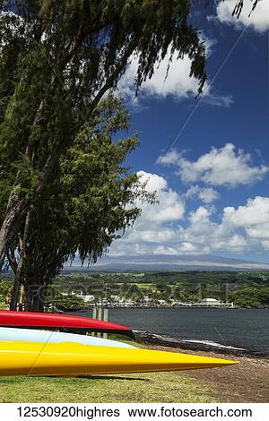 Stock Photograph - Colourful canoes on the shore at Hilo canoe club; Hilo, Island of Hawaii, Hawaii, United States of America. Fotosearch