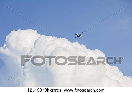 Commercial airliner and bank of clouds in a blue sky; Georgetown, Ontario, Canada View Large Photo Image Stock Photograph - Commercial airliner and bank of clouds in a blue sky; Georgetown, Ontario, Canada. Fotosearch