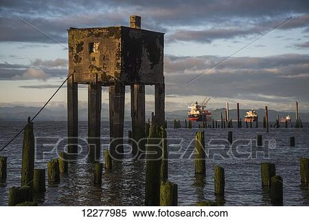 Concrete structure and wooden pilings along the riverwalk with ships in the background; Astoria, Oregon, United States of America View Large Photo Image Stock Photography - Concrete structure and wooden pilings along the riverwalk with ships in the background; Astoria, Oregon, United States of America. Fotosearch