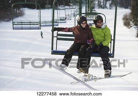 Couple ride the chair lift at Hilltop Ski Area in Anchorage, Alaska View Large Photo Image Stock Photo - Couple ride the chair lift at Hilltop Ski Area in Anchorage, Alaska. Fotosearch