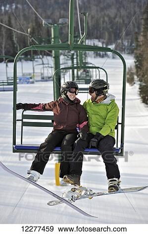 Couple ride the chair lift at Hilltop Ski Area in Anchorage, Alaska View Large Photo Image Stock Photo - Couple ride the chair lift at Hilltop Ski Area in Anchorage, Alaska. Fotosearch
