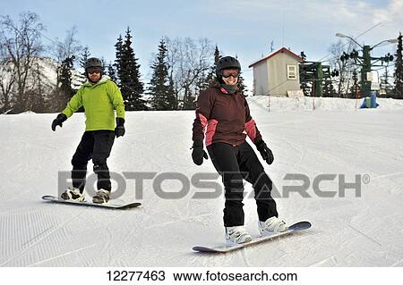 Couple snowboarding at Hilltop Ski Area in Anchorage, Alaska View Large Photo Image Stock Image - Couple snowboarding at Hilltop Ski Area in Anchorage, Alaska. Fotosearch
