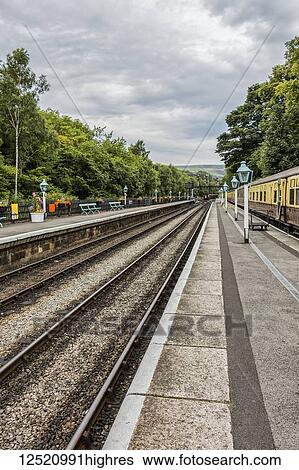 Stock Photograph - Diminishing perspective of the tracks and lamps at Goathland station; Yorkshire, England. Fotosearch