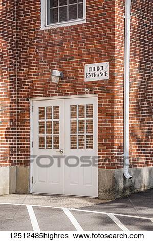 Stock Photograph - Doors on a brick wall of a church building with sign above reading 'Church Entrance'; Connecticut, United States of America. Fotosearch