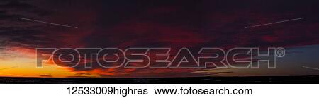 Stock Photograph - Dramatic colourful chinook cloud formation at sunrise; Calgary, Alberta, Canada. Fotosearch