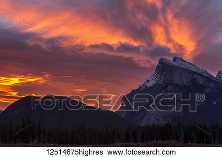 Dramatic glowing clouds over the rugged peaks of the Rocky mountains in Banff National Park; Banff, Alberta, Canada View Large Photo Image Stock Photograph - Dramatic glowing clouds over the rugged peaks of the Rocky mountains in Banff National Park; Banff, Alberta, Canada. Fotosearch