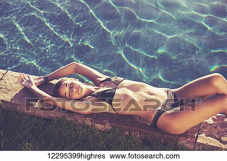 Fashion Lifestyle, Beautiful Woman In Swimwear Relaxing By The Pool At Sunset View Large Photo Image Stock Photograph - Fashion Lifestyle, Beautiful Woman In Swimwear Relaxing By The Pool At Sunset. Fotosearch