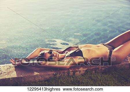 Fashion Lifestyle, Beautiful Woman In Swimwear Relaxing By The Pool At Sunset View Large Photo Image Stock Photograph - Fashion Lifestyle, Beautiful Woman In Swimwear Relaxing By The Pool At Sunset. Fotosearch