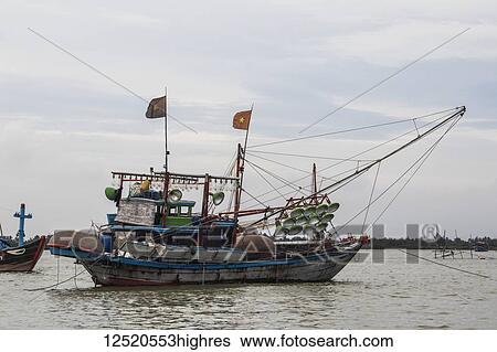 Stock Photograph - Fishing boat in the river; Hoi An, Quang Nam, Vietnam. Fotosearch