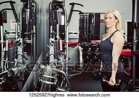 Fitness club owner teaching how to lift free weights and turning to look at the camera; Spruce Grove, Alberta, Canada View Large Photo Image Stock Photograph - Fitness club owner teaching how to lift free weights and turning to look at the camera; Spruce Grove, Alberta, Canada. Fotosearch