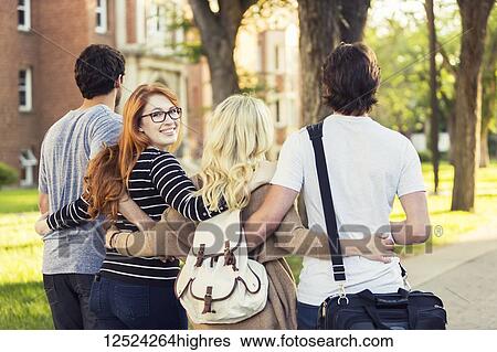 Four friends walking and talking in an embrace on the university campus with a female looking back at the camera; Edmonton, Alberta, Canada View Large Photo Image Stock Photograph - Four friends walking and talking in an embrace on the university campus with a female looking back at the camera; Edmonton, Alberta, Canada. Fotosearch