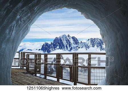Stock Photograph - French Alps and Aiguille du midi panoramic viewing deck through the ice cave; Chamonix-Mont-Blanc, Rhone-Alpes, France. Fotosearch