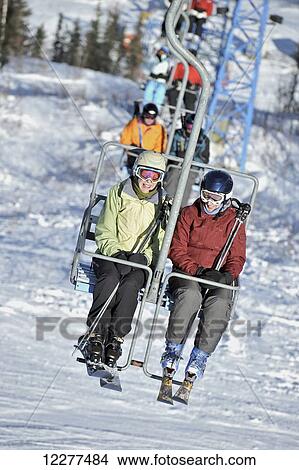 Picture - Friends ride the 3800-feet double chairlift at Mt. Aurora Skiland near Cleary Summit north of Fairbanks, Alaska.. Fotosearch