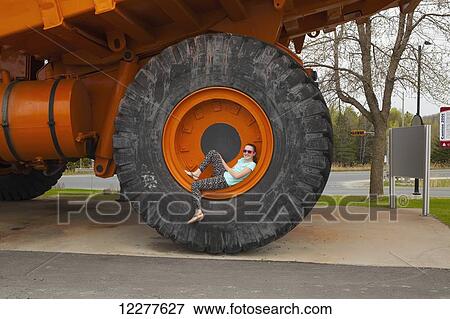Girl sitting inside wheel rim of 200 ton truck used in Jeffery mine; Asbestos, Quebec, Canada View Large Photo Image Stock Photo - Girl sitting inside wheel rim of 200 ton truck used in Jeffery mine; Asbestos, Quebec, Canada. Fotosearch