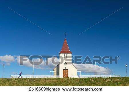 Stock Photograph - Girl walking past small church; Langaholt, Iceland. Fotosearch