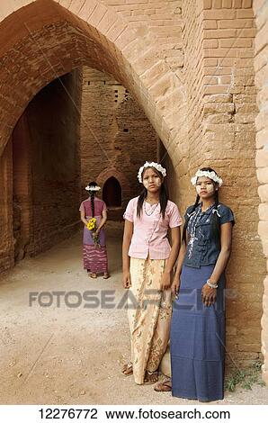 Girls with flower garland and face paint standing against a wall; Bagan, Myanmar View Large Photo Image Stock Image - Girls with flower garland and face paint standing against a wall; Bagan, Myanmar. Fotosearch