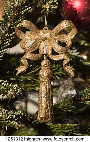 Stock Photograph - Golden tassel with bow on Christmas tree; London, England. Fotosearch