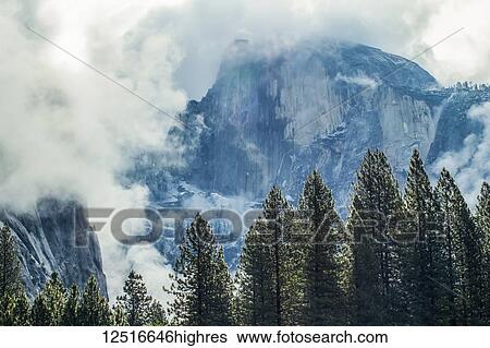 Stock Photograph - Half Dome surrounded by clouds, Yosemite National Park; California, United States of America. Fotosearch