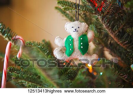Stock Photograph - Hand-sewn teddy bear Christmas ornament hanging on a Christmas tree; Waco, Texas, United States of America. Fotosearch