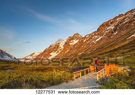 Hiker crosses a foot bridge to Hidden Lakes Trail in the evening light, Chugach State Park, Southcentral Alaska View Large Photo Image Stock Image - Hiker crosses a foot bridge to Hidden Lakes Trail in the evening light, Chugach State Park, Southcentral Alaska. Fotosearch