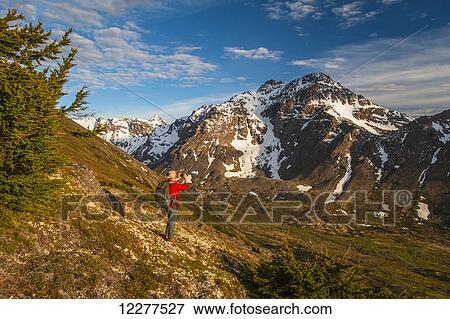 Hiker on a hillside that overlooks Powerline Pass valley and trail, Chugach State Park, Southcentral Alaska View Large Photo Image Stock Photo - Hiker on a hillside that overlooks Powerline Pass valley and trail, Chugach State Park, Southcentral Alaska. Fotosearch