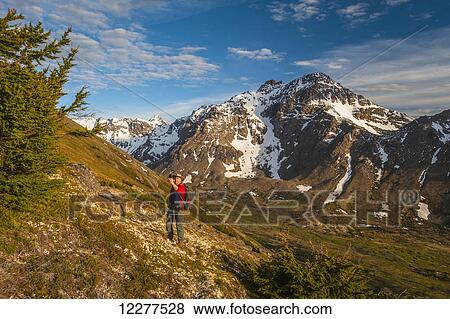 Hiker on a hillside that overlooks Powerline Pass valley and trail takes a selfie, Chugach State Park, Southcentral Alaska View Large Photo Image Stock Photo - Hiker on a hillside that overlooks Powerline Pass valley and trail takes a selfie, Chugach State Park, Southcentral Alaska. Fotosearch