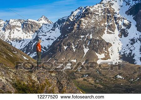 Hiker on rock outcrop overlooks Powerline Pass valley and trail, Chugach State Park, Southcentral Alaska View Large Photo Image Stock Image - Hiker on rock outcrop overlooks Powerline Pass valley and trail, Chugach State Park, Southcentral Alaska. Fotosearch