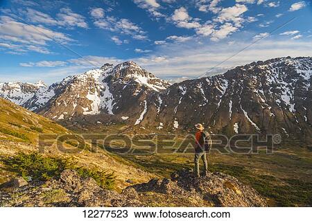 Hiker on rock outcrop overlooks Powerline Pass valley and trail, Chugach State Park, Southcentral Alaska View Large Photo Image Stock Image - Hiker on rock outcrop overlooks Powerline Pass valley and trail, Chugach State Park, Southcentral Alaska. Fotosearch