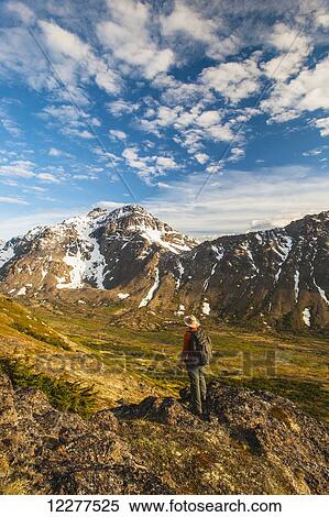 Hiker on rock outcrop overlooks Powerline Pass valley and trail, Chugach State Park, Southcentral Alaska View Large Photo Image Stock Photography - Hiker on rock outcrop overlooks Powerline Pass valley and trail, Chugach State Park, Southcentral Alaska. Fotosearch